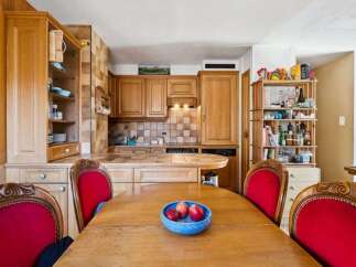 This charming kitchen boasts beautiful wooden cabinetry and a cozy dining area.