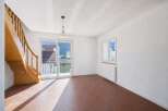 Discover this bright and airy living space, featuring a beautiful wooden staircase and a charming pendant light.