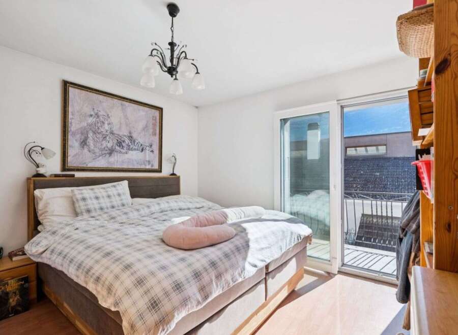 This bright and airy bedroom offers a serene retreat with its neutral color palette and ample natural light.