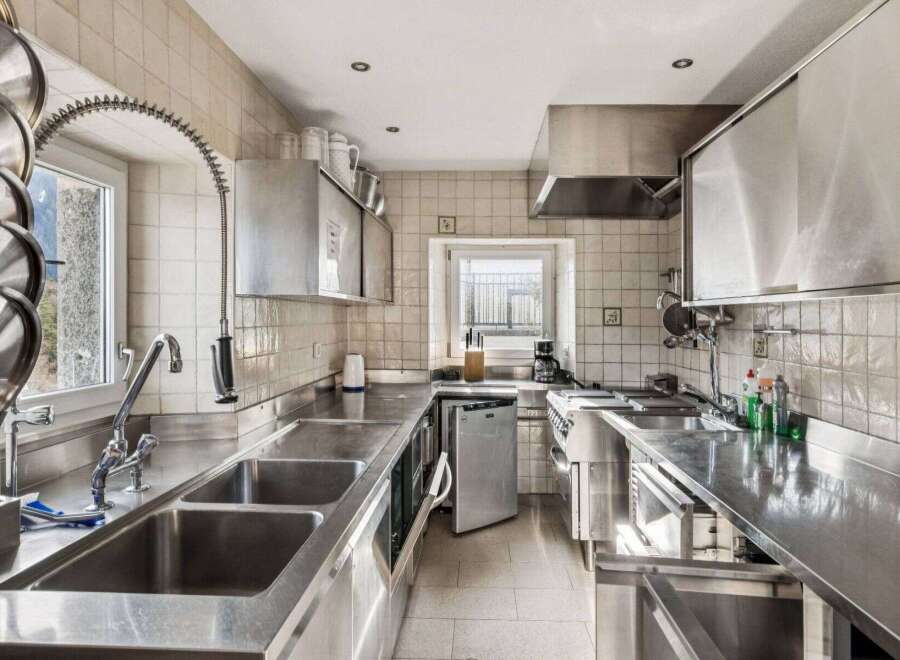 This commercial kitchen boasts a sleek, stainless steel design, perfect for culinary professionals.
