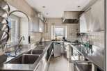 This commercial kitchen boasts a sleek, stainless steel design, perfect for culinary professionals.