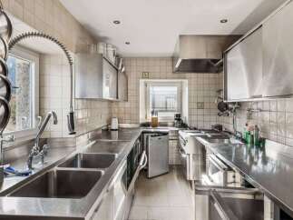 This commercial kitchen boasts a sleek, stainless steel design, perfect for culinary professionals.