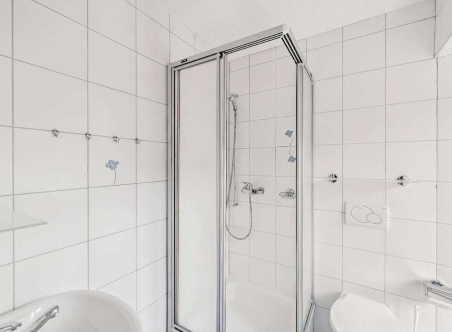 Step into this bright and airy bathroom featuring a modern glass shower enclosure.