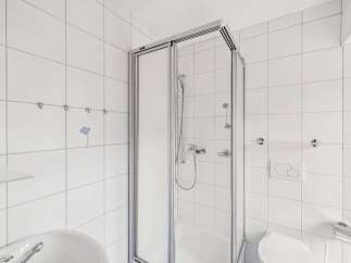 Step into this bright and airy bathroom featuring a modern glass shower enclosure.