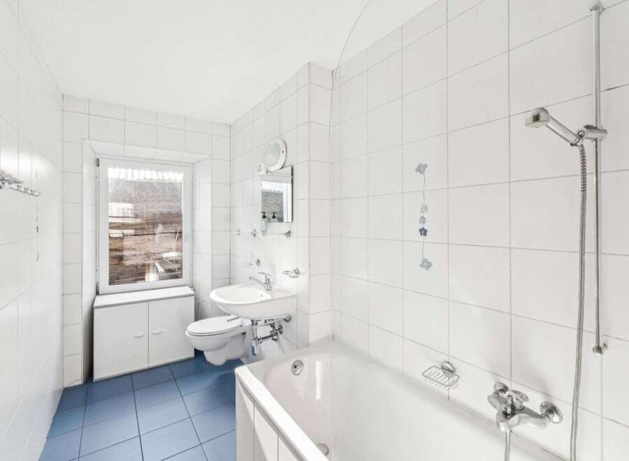 This bright and airy bathroom features pristine white tile, creating a clean and modern aesthetic.
