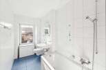 This bright and airy bathroom features pristine white tile, creating a clean and modern aesthetic.
