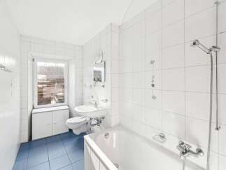 This bright and airy bathroom features pristine white tile, creating a clean and modern aesthetic.
