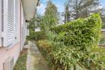 Discover the charm of this property, featuring a serene pathway lined with lush greenery.
