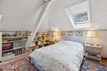 This charming bedroom features a cozy bed with a floral patterned duvet, perfect for a relaxing retreat.