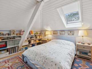 This charming bedroom features a cozy bed with a floral patterned duvet, perfect for a relaxing retreat.