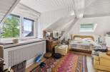 This charming bedroom features a unique sloped ceiling and a cozy atmosphere.