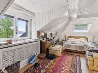 This charming bedroom features a unique sloped ceiling and a cozy atmosphere.