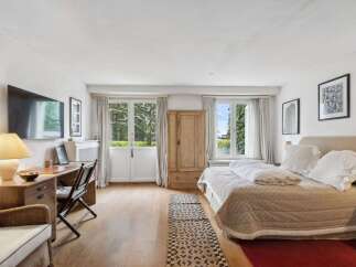 Discover the charm of this inviting bedroom, featuring a blend of natural light and elegant design.