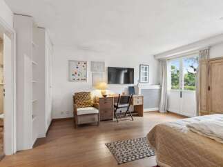 This bright and airy bedroom offers a comfortable and stylish living space.