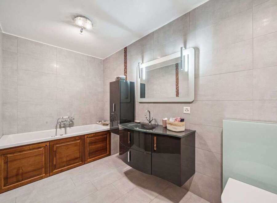 Step into luxury with this stunning bathroom! Featuring a sleek, modern vanity with ample storage, and a relaxing bathtub, this space is designed for ultimate comfort.