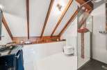 This stunning bathroom boasts a unique design with exposed wooden beams and a modern aesthetic.