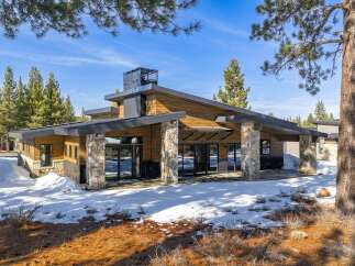 This stunning modern home boasts a striking exterior with a combination of wood and stone accents.
