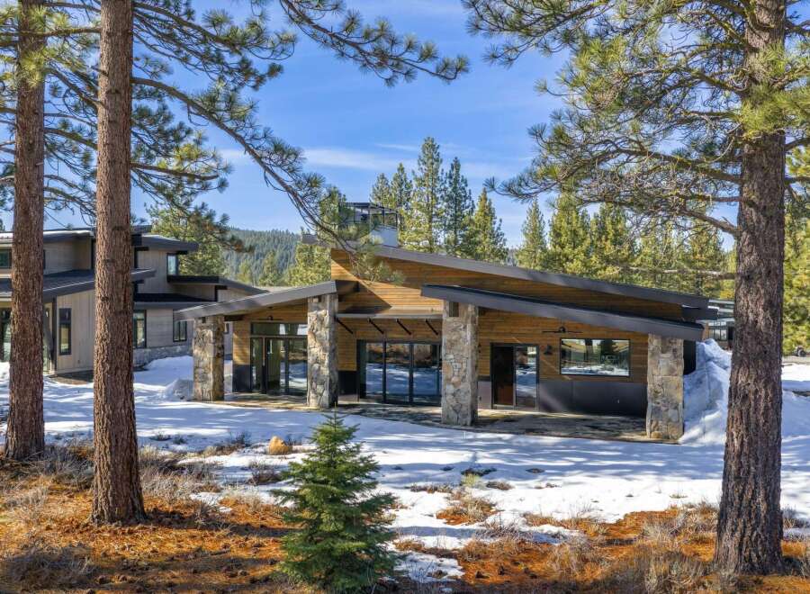 Nestled in a serene, snow-covered landscape, this stunning property boasts a modern architectural design with a blend of natural elements.