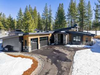This stunning modern home boasts a sleek design with a blend of wood and stone accents.