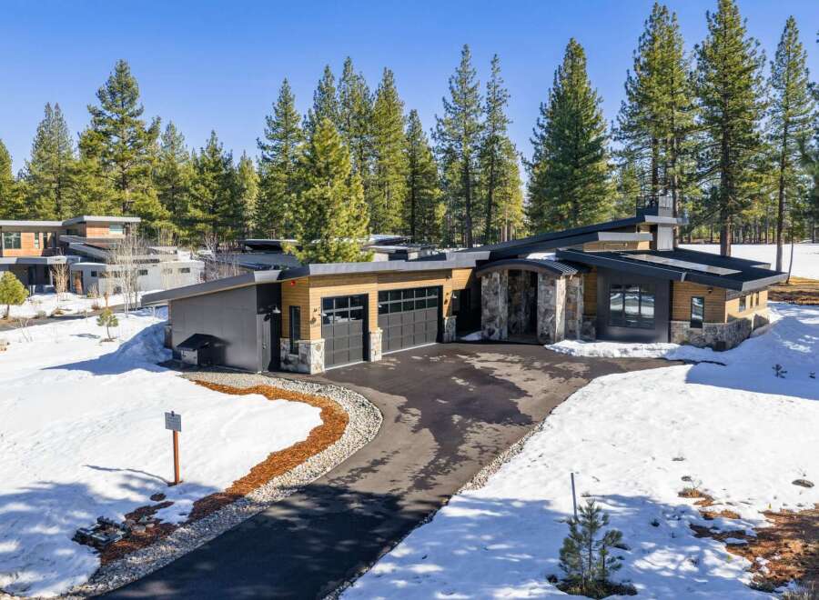 This stunning modern home boasts a sleek design with a blend of natural wood and stone accents.