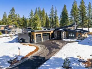 This stunning modern home boasts a sleek design with a blend of natural wood and stone accents.