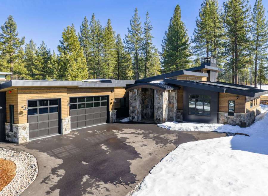 This stunning modern home boasts a sleek design with a combination of wood and stone elements.