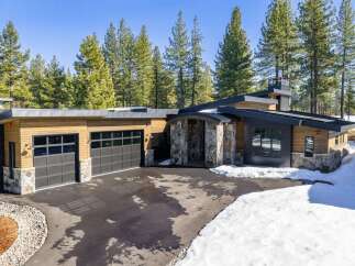 This stunning modern home boasts a sleek design with a combination of wood and stone elements.