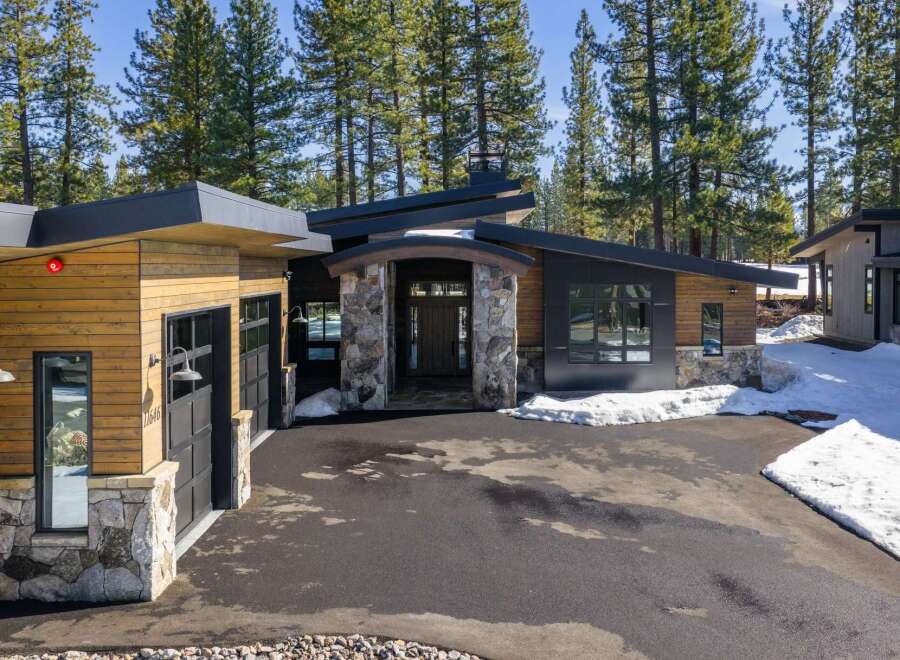 This stunning modern home boasts a striking exterior with a combination of wood and stone accents.