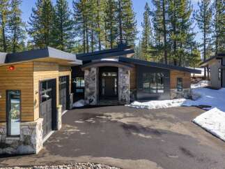 This stunning modern home boasts a striking exterior with a combination of wood and stone accents.