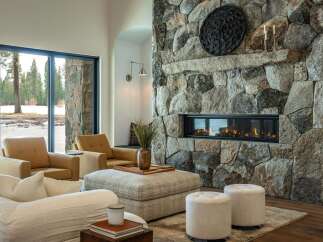 Experience luxury living in this stunning property featuring a grand stone fireplace, perfect for cozy evenings.