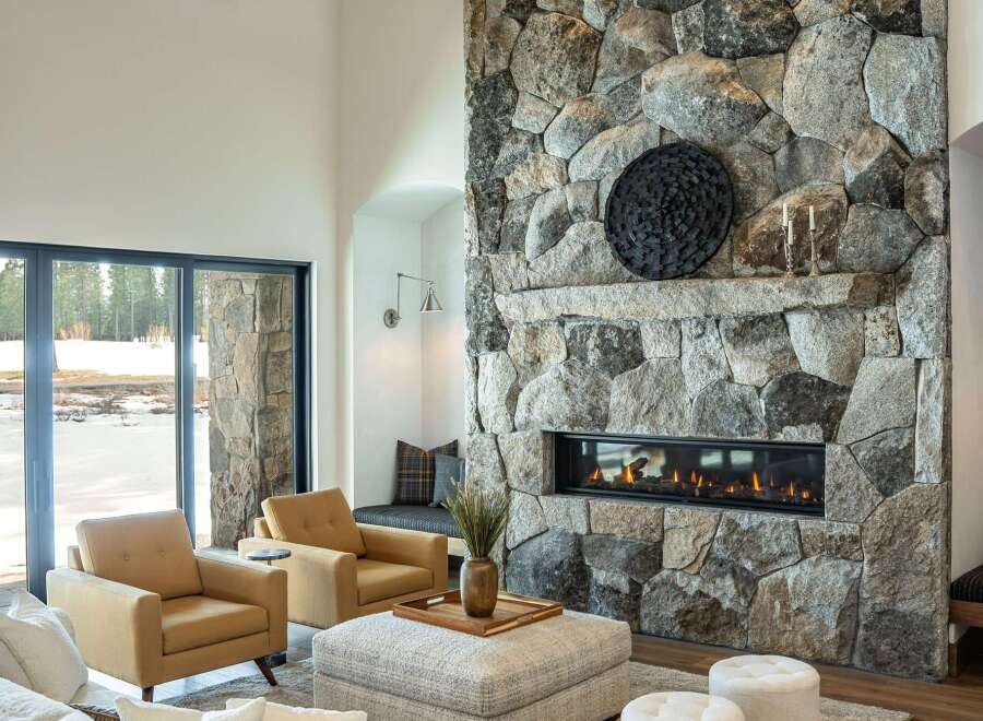 Experience luxury living in this stunning property featuring a grand stone fireplace, perfect for cozy evenings.