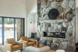 Experience luxury living in this stunning property featuring a grand stone fireplace, perfect for cozy evenings.