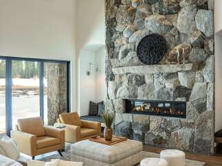 Experience luxury living in this stunning property featuring a grand stone fireplace, perfect for cozy evenings.
