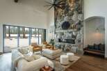 This stunning living room boasts a striking stone fireplace, creating a cozy and inviting atmosphere.
