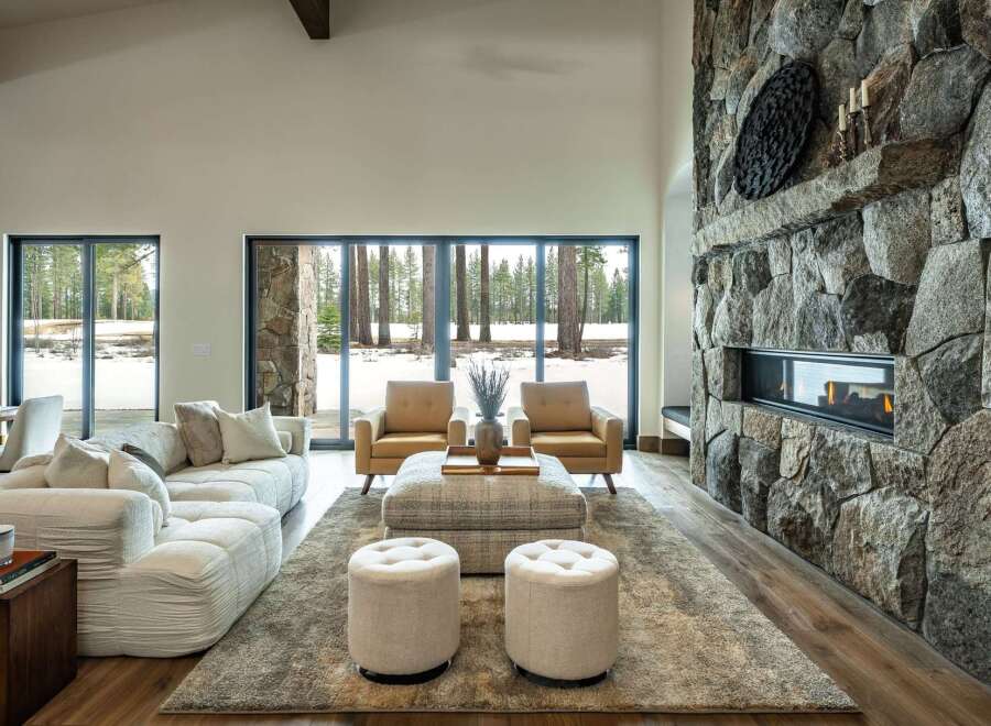 Experience luxury living in this stunning property featuring a grand stone fireplace, creating a cozy ambiance.
