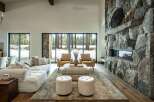 Experience luxury living in this stunning property featuring a grand stone fireplace, creating a cozy ambiance.