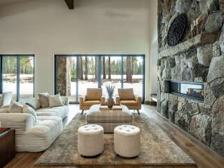 Experience luxury living in this stunning property featuring a grand stone fireplace, creating a cozy ambiance.