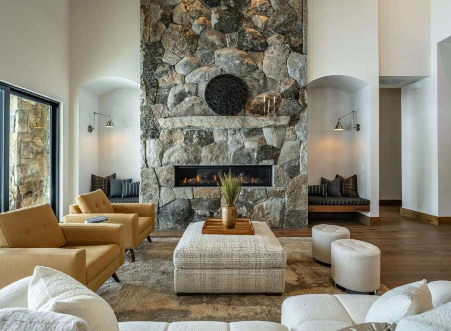 This stunning property boasts a luxurious living room with a striking stone fireplace, creating a warm and inviting atmosphere.
