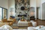 This stunning property boasts a luxurious living room with a striking stone fireplace, creating a warm and inviting atmosphere.