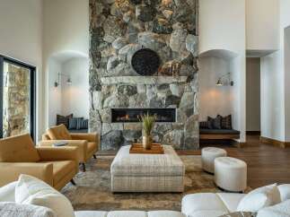This stunning property boasts a luxurious living room with a striking stone fireplace, creating a warm and inviting atmosphere.