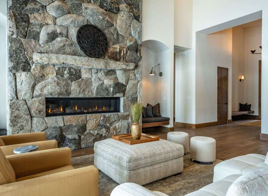 Experience luxury living in this stunning property featuring a grand stone fireplace, perfect for cozy evenings.