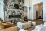 Experience luxury living in this stunning property featuring a grand stone fireplace, perfect for cozy evenings.