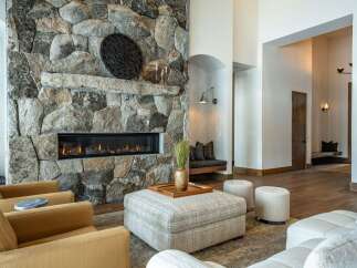 Experience luxury living in this stunning property featuring a grand stone fireplace, perfect for cozy evenings.