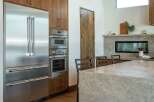 This stunning kitchen boasts high-end stainless steel appliances, including a refrigerator, oven, and microwave, seamlessly integrated into custom cabinetry.