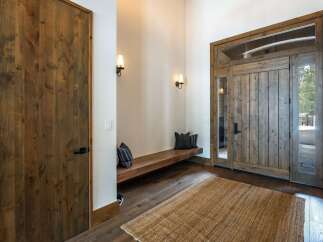 Step into luxury with this stunning entryway! Featuring a beautiful wooden door and a cozy bench, this space is perfect for welcoming guests.