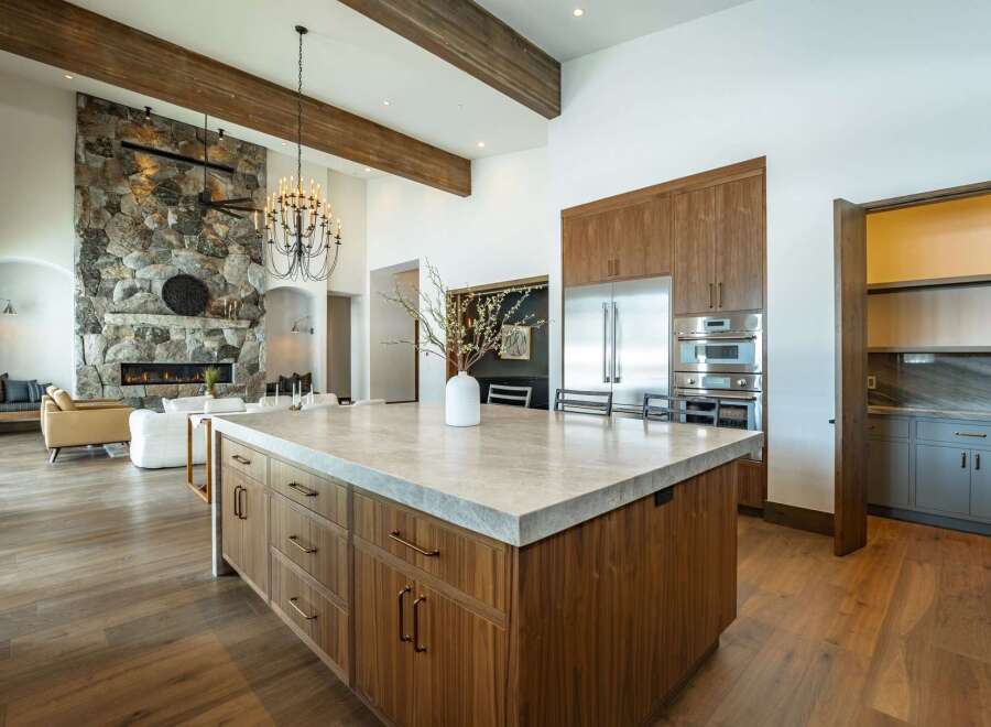 Experience luxury living in this stunning kitchen, featuring a spacious island with a sleek countertop and custom cabinetry.
