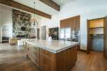 Experience luxury living in this stunning kitchen, featuring a spacious island with a sleek countertop and custom cabinetry.