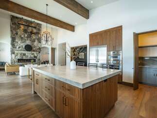 Experience luxury living in this stunning kitchen, featuring a spacious island with a sleek countertop and custom cabinetry.