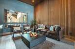 Step into luxury with this stunning living room, featuring a cozy leather sofa and elegant wood paneling.