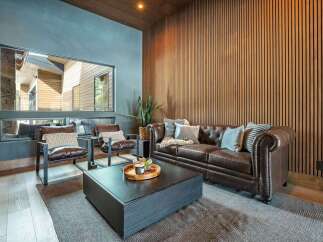 Step into luxury with this stunning living room, featuring a cozy leather sofa and elegant wood paneling.